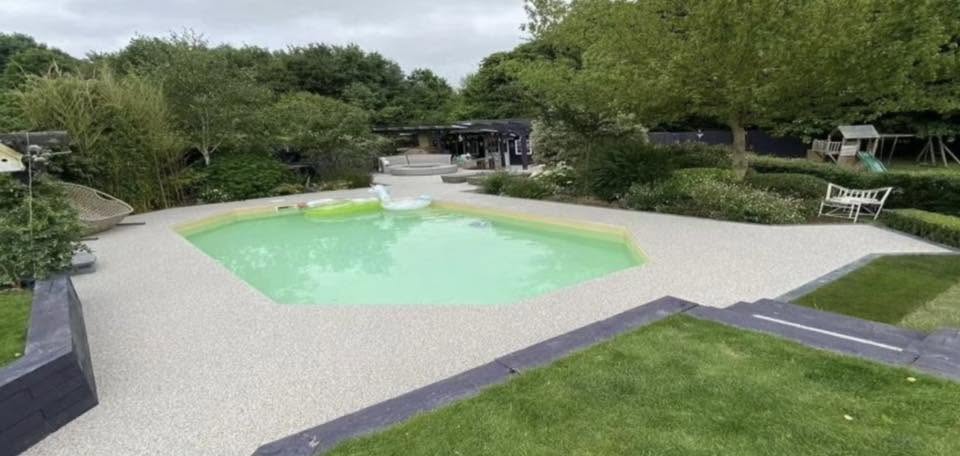 Resin wash stone poolside terrace with a contrasting dark border
